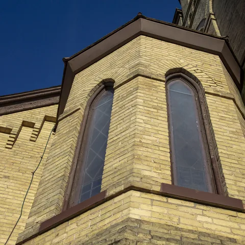 Tall arched windows in an angular brick window bay
