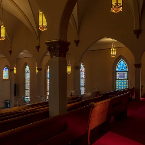 Wooden pews, vaulted arches and stained glass inside the sanctuary