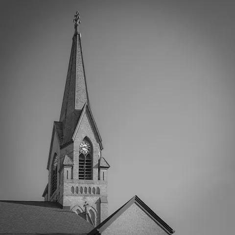 Black and white view of the church spire and clock tower