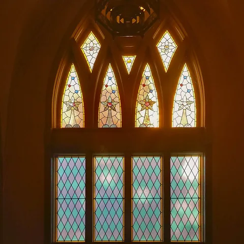 Warm light through an ornate Gothic stained-glass window